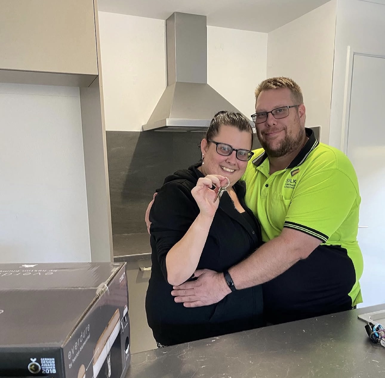 Couple celebrating with keys in their new kitchen