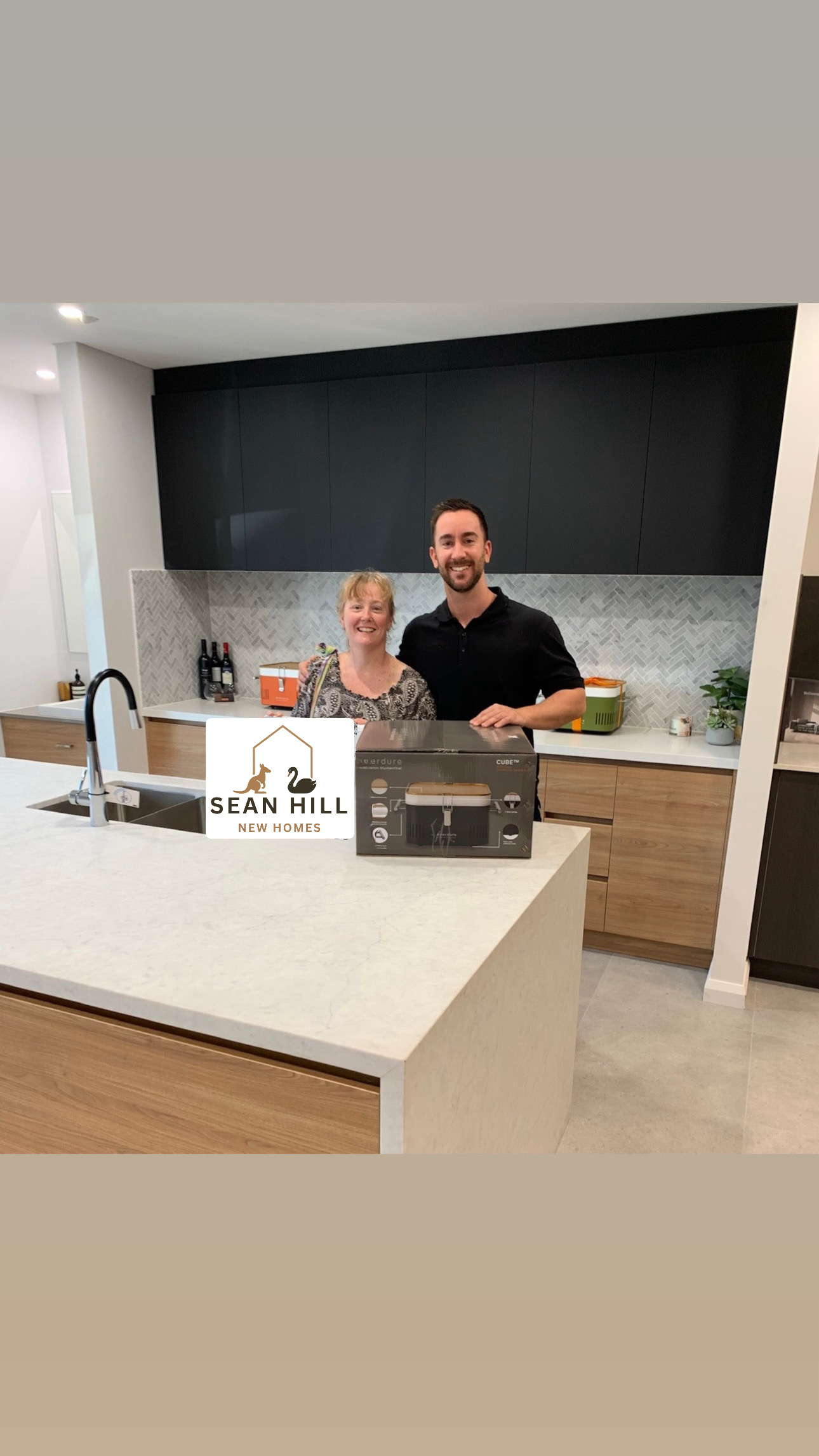 Happy clients celebrating in their new kitchen with Sean