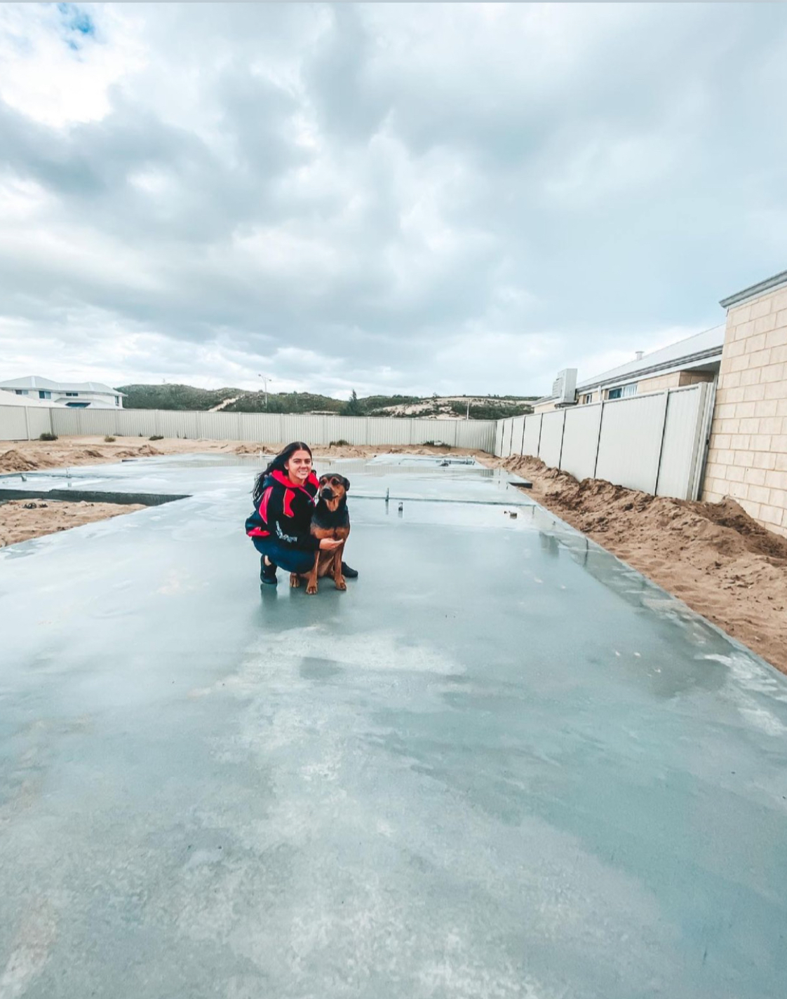 Woman with her dog on new home foundation